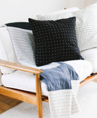 modern black throw pillow sitting on mid-century modern futon or daybed with coordinating white pillow