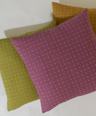 pile of cross-stitch throw pillows