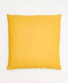 back of mustard yellow throw pillow with cross-stitch pattern on front and solid back