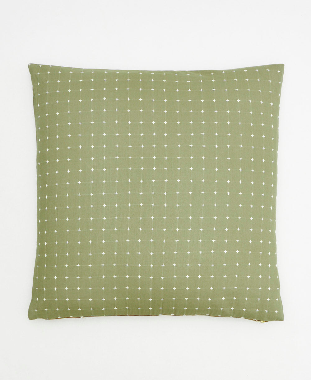 sage green throw pillow with white embroidered tiny cross-stitch pattern on front