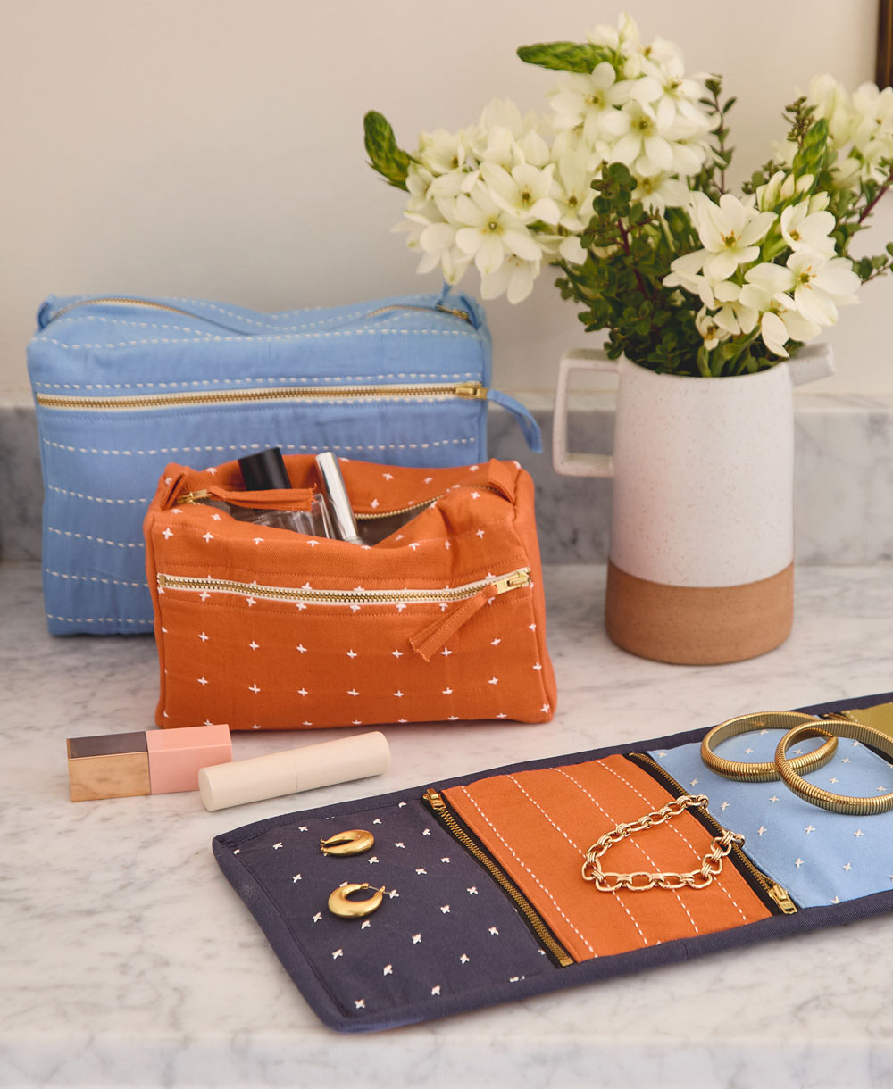 orange and blue toiletry bags sitting on a gray bathroom vanity