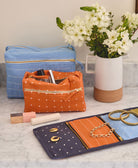 orange and blue toiletry bags sitting on a gray bathroom vanity