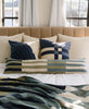 handmade cotton modern throw pillows on neutral bed with pops of navy