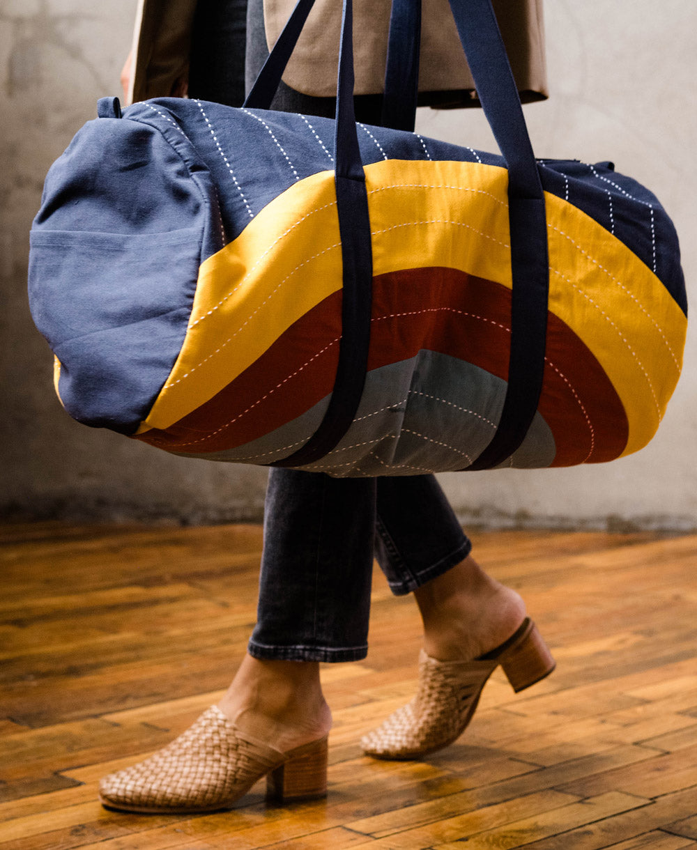 modern barrel shaped duffel bag with abstract rainbow design