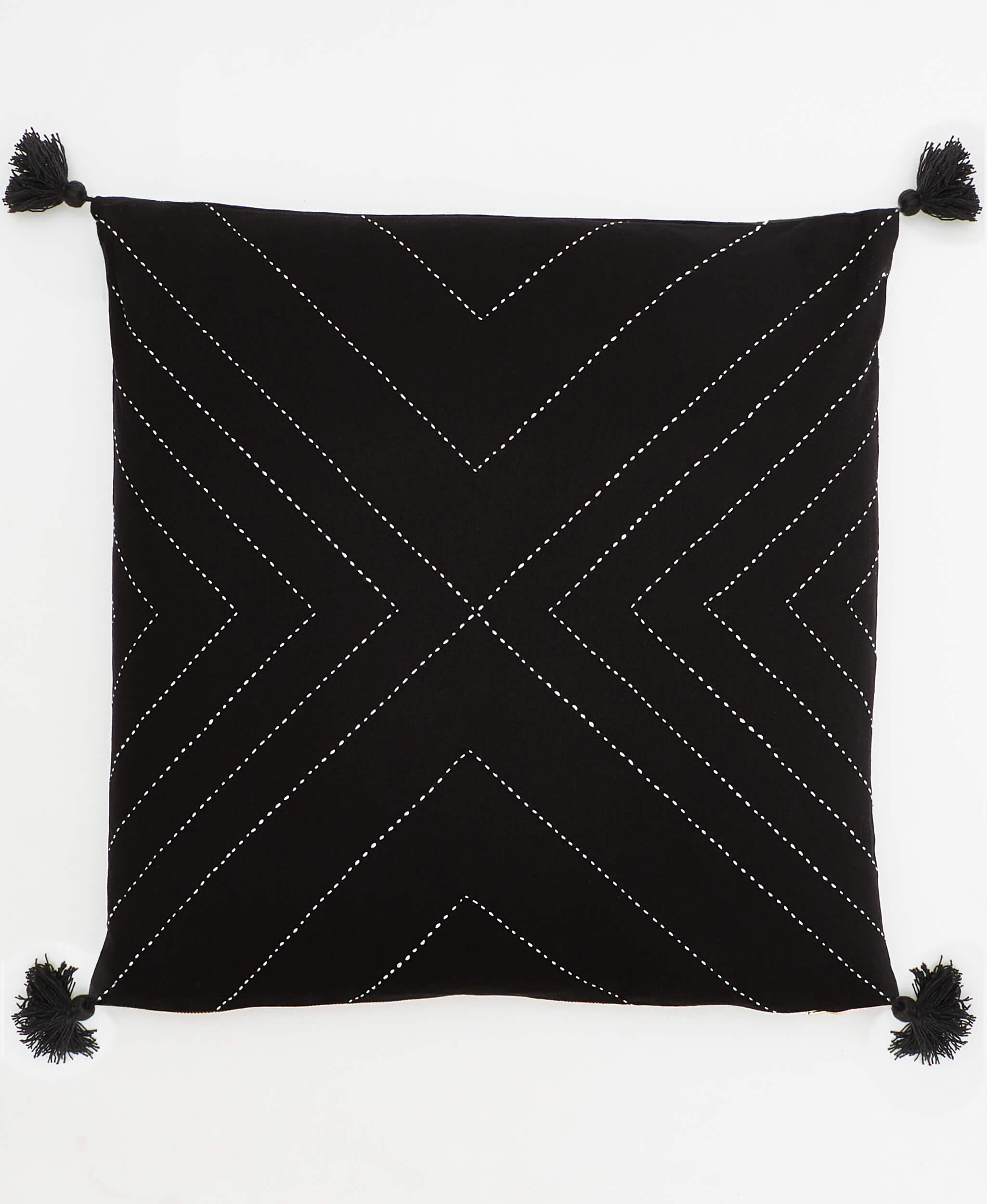 black geometric throw pillow with white embroidery and black tassels on each corner