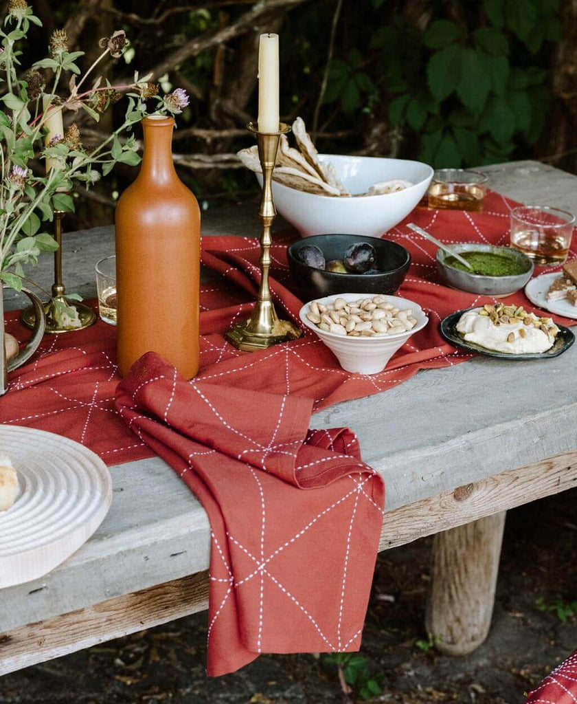 outdoor autumn tablescape with graphic rust table runner with brass candlesticks