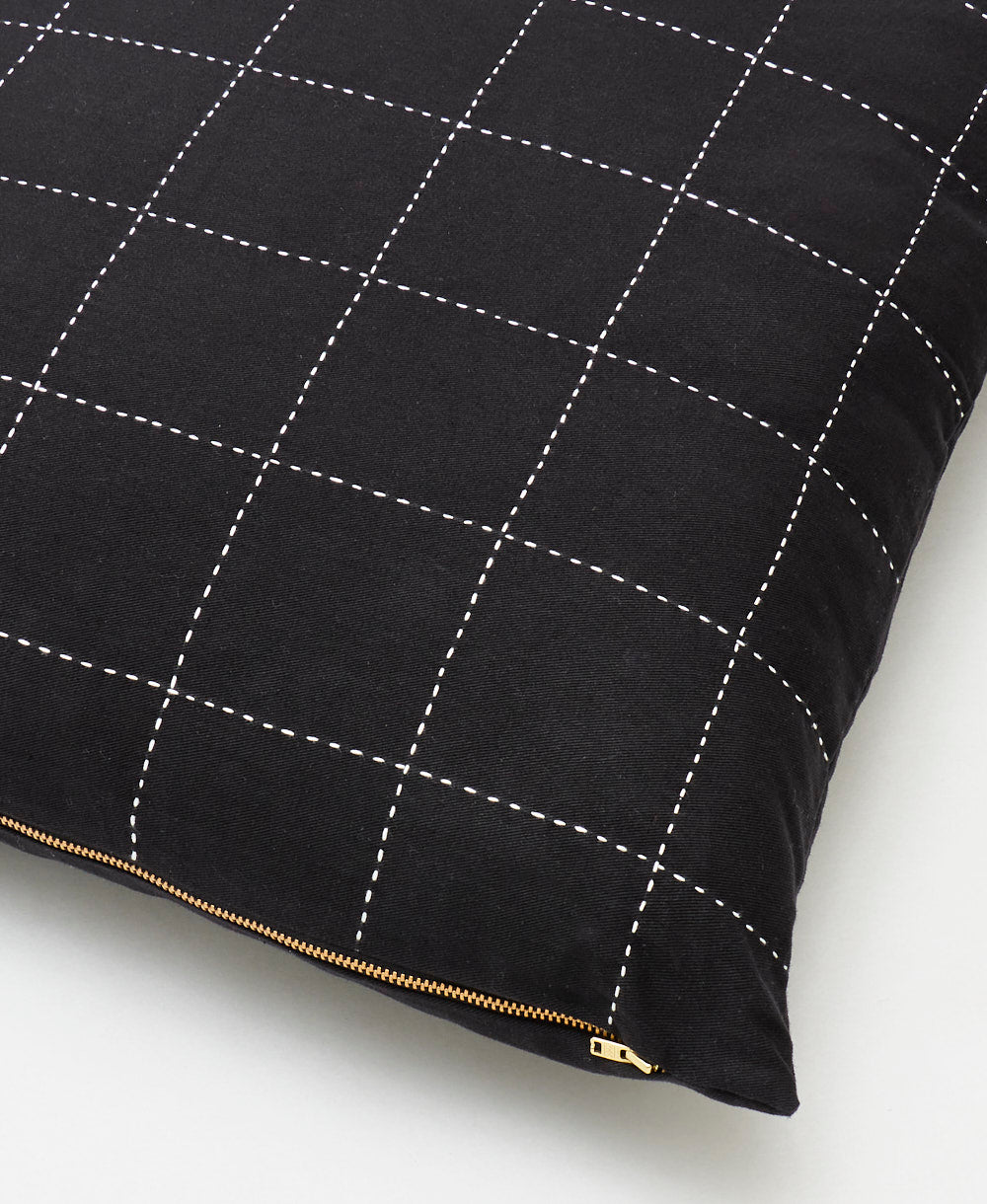 organic cotton black square pillow with white embroidery forming a grid pattern