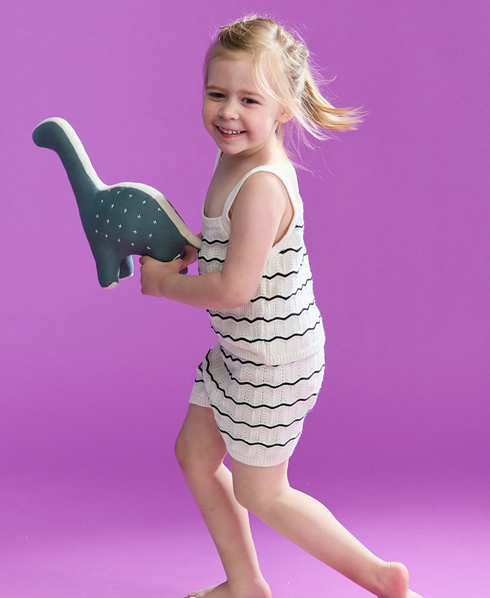 little girl running and holding dinosaur stuffed animal