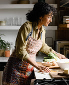 woman wearing kantha bib apron with adjustable neck tie & waist tie in subtle paisley print