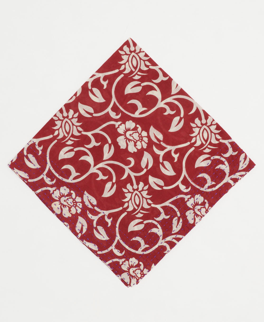 cherry red bandana with a white graphic floral print and hand-embroidered edges