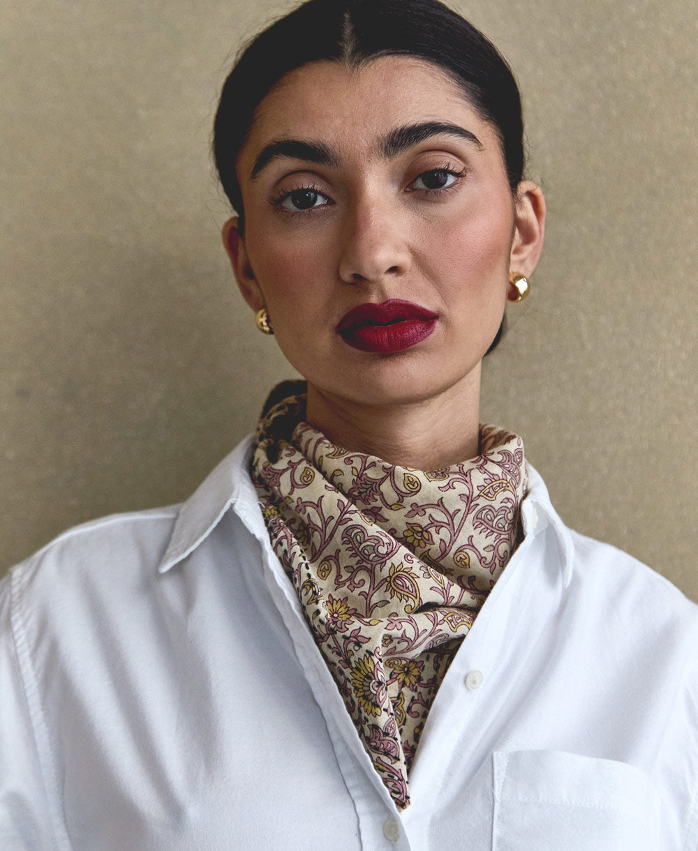 woman wearing white button-up collared shirt with lavender and yellow floral cotton bandana tied around neck