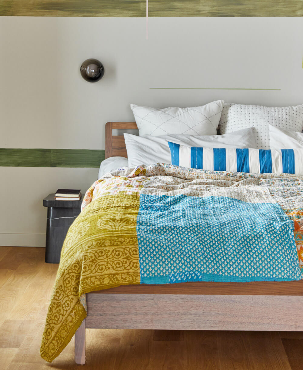 one-of-a-kind king kantha quilt with lime green, blue and orange on all white bed