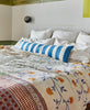 handmade kantha quilt in orange and blue florals on modern all white bed