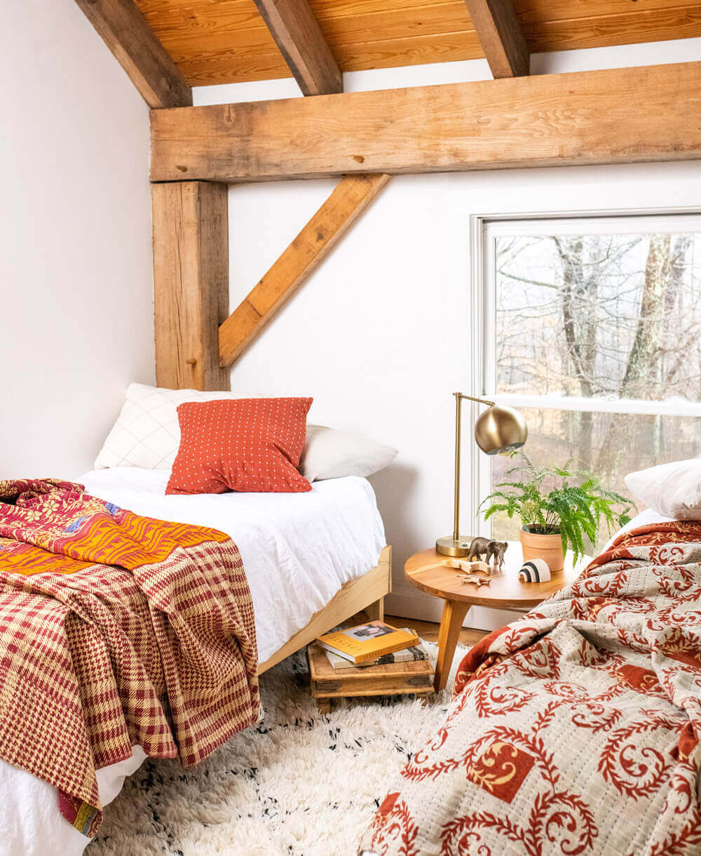 pair of coordinating twin kantha quilts in shades of rust and orange in double twin bed room