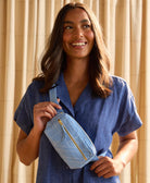 woman holding dusk blue crossbody belt bag