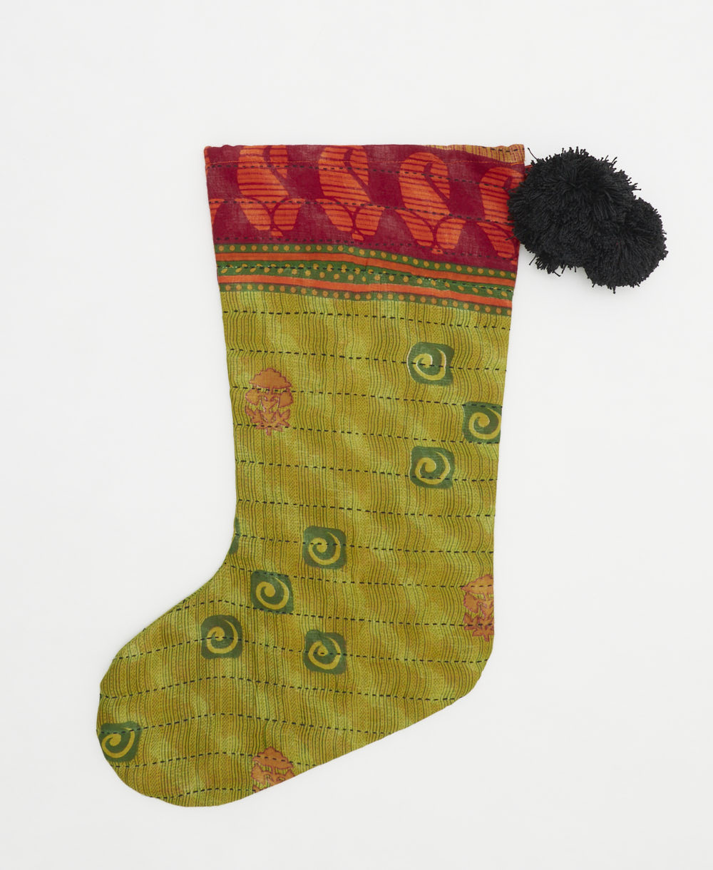 unique holiday stocking handmade from vintage cotton saris in India featuring an olive green subtle stripe print with black pom poms