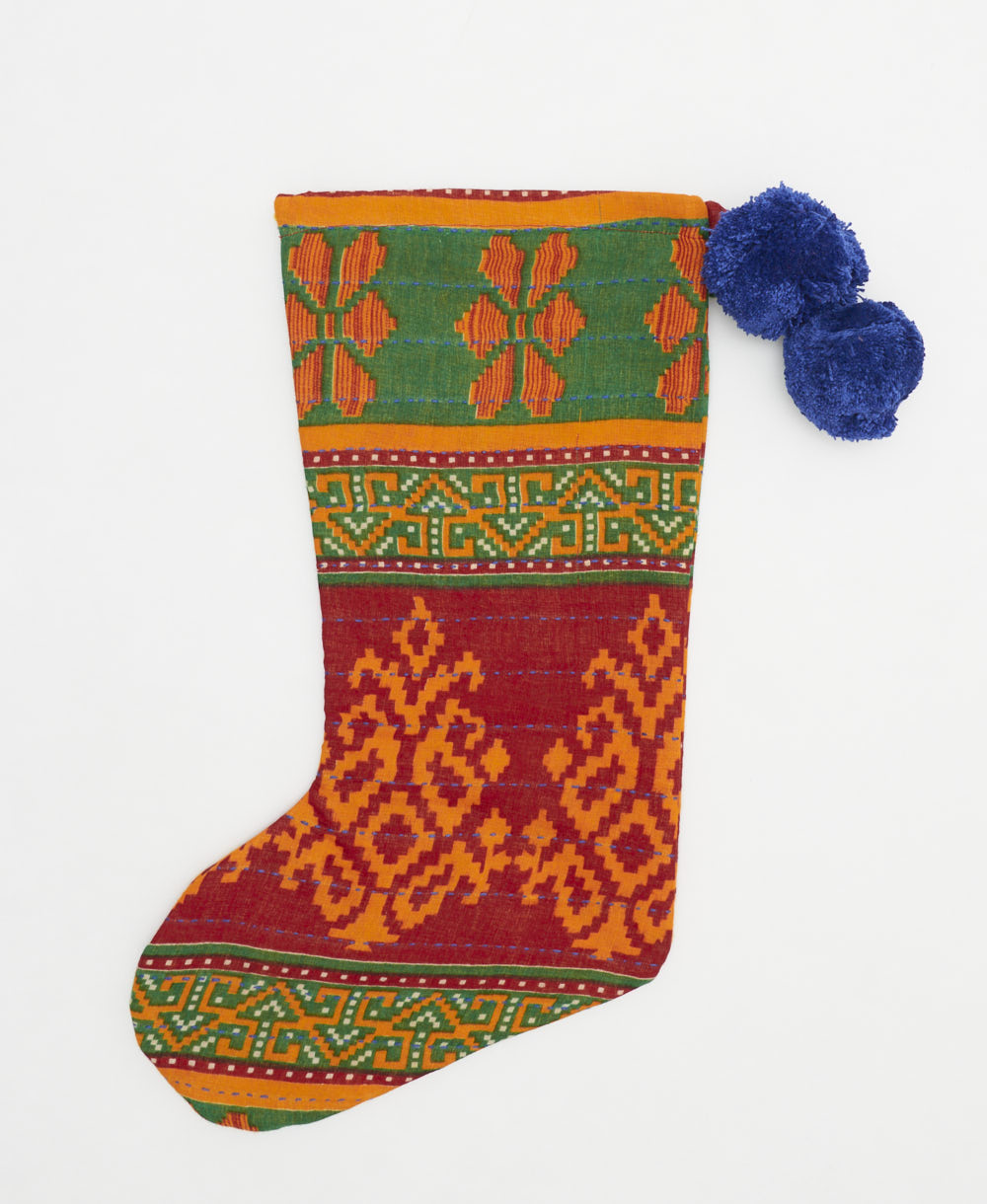 crimson red & grass-green holiday stocking in geometric floral print with royal blue pom poms