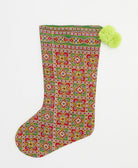 green & red holiday stocking in checkered print with neon yellow pom poms