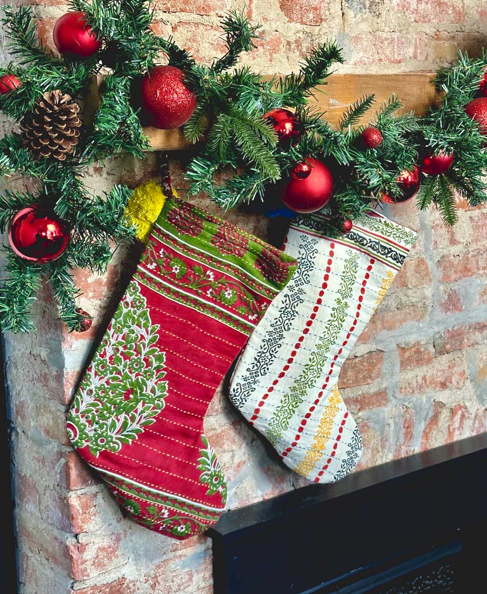 kantha vintage stocking in mixed vintage fabrics hanging from wooden mantel above brick fireplace