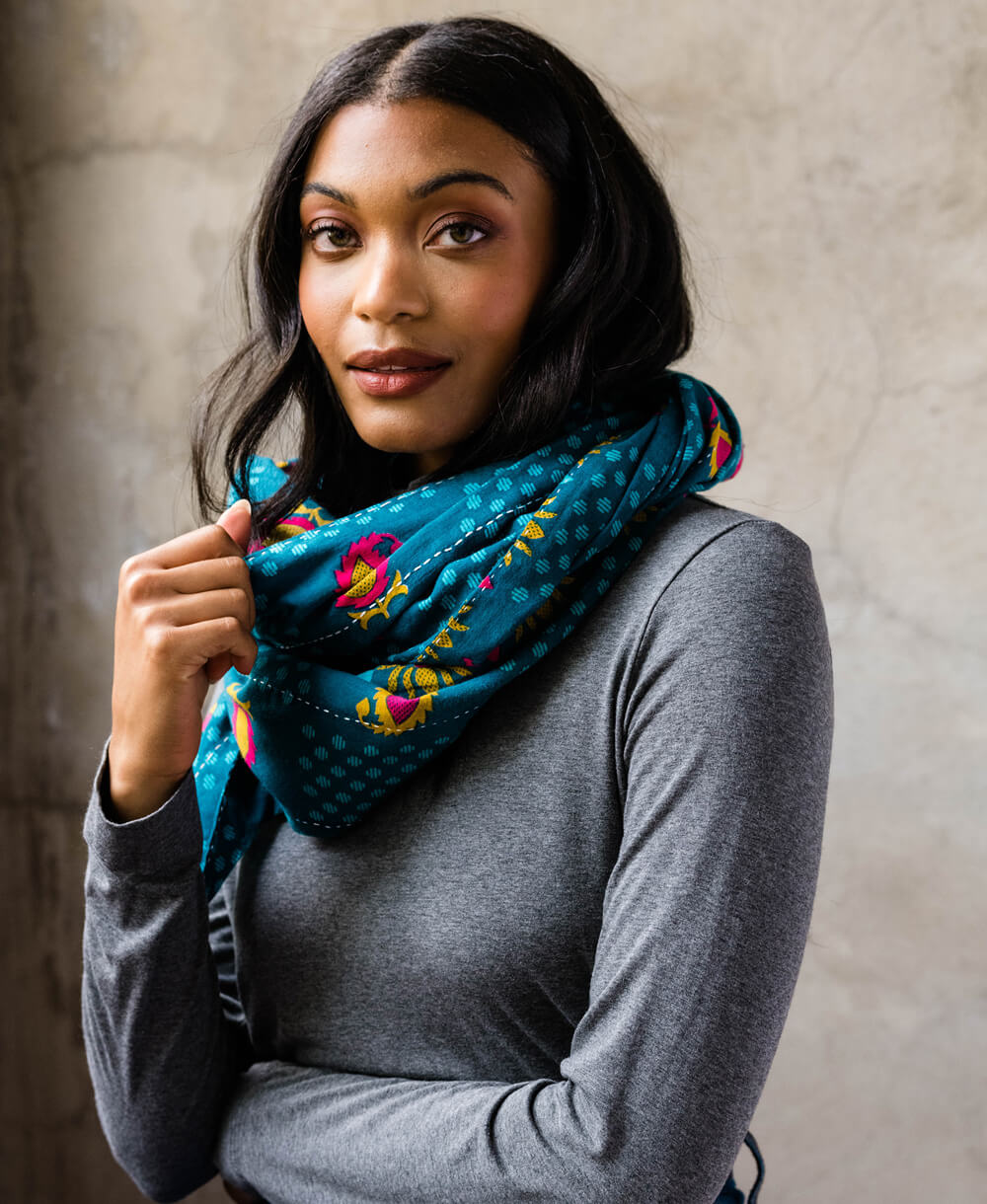 brunette woman wearing bold blue oversized scarf draped around her neck