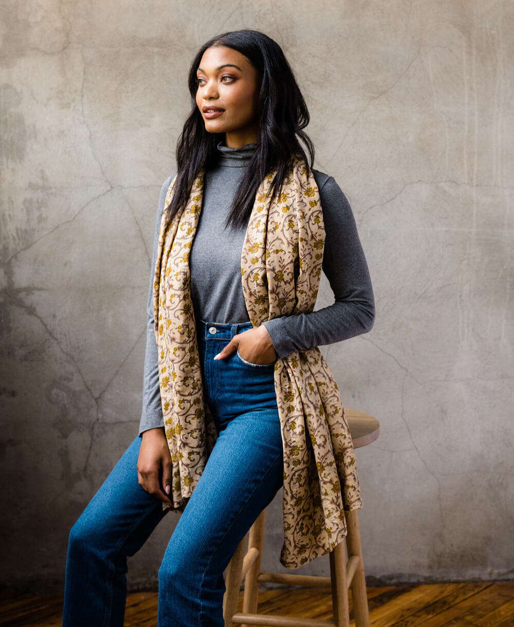 woman wearing long cotton scarf in a tan and mustard yellow floral print perfect for autumn