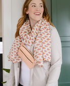 woman with red hair wearing white and pink floral cotton long scarf with matching pink fanny pack