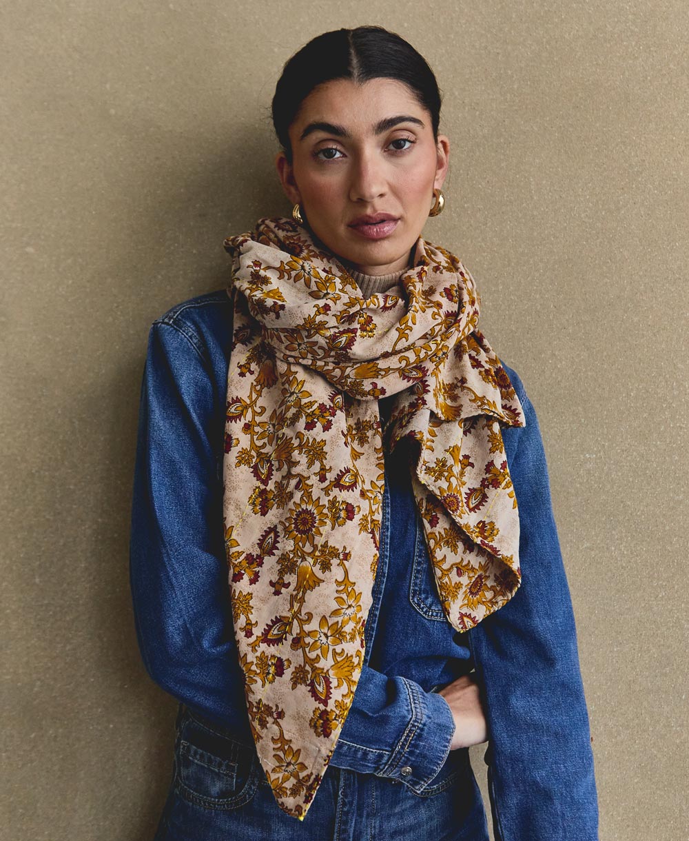 long lightweight scarf in cotton in mustard and maroon paisley wrapped around neck of woman in denim shirt and vintage jeans