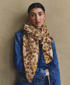 long lightweight scarf in cotton in mustard and maroon paisley wrapped around neck of woman in denim shirt and vintage jeans