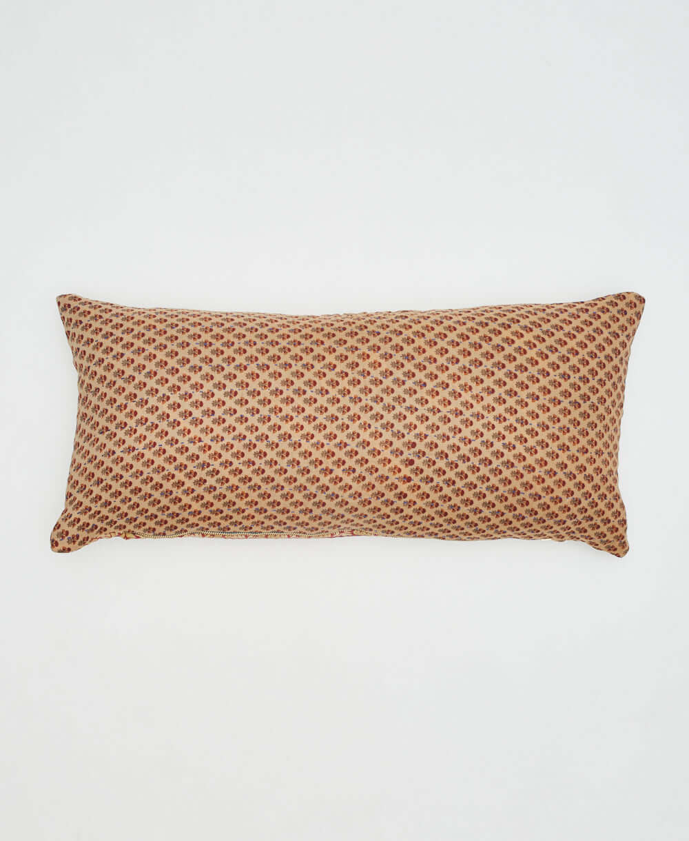 beige lumbar pillow with tiny rust & crimson flowers