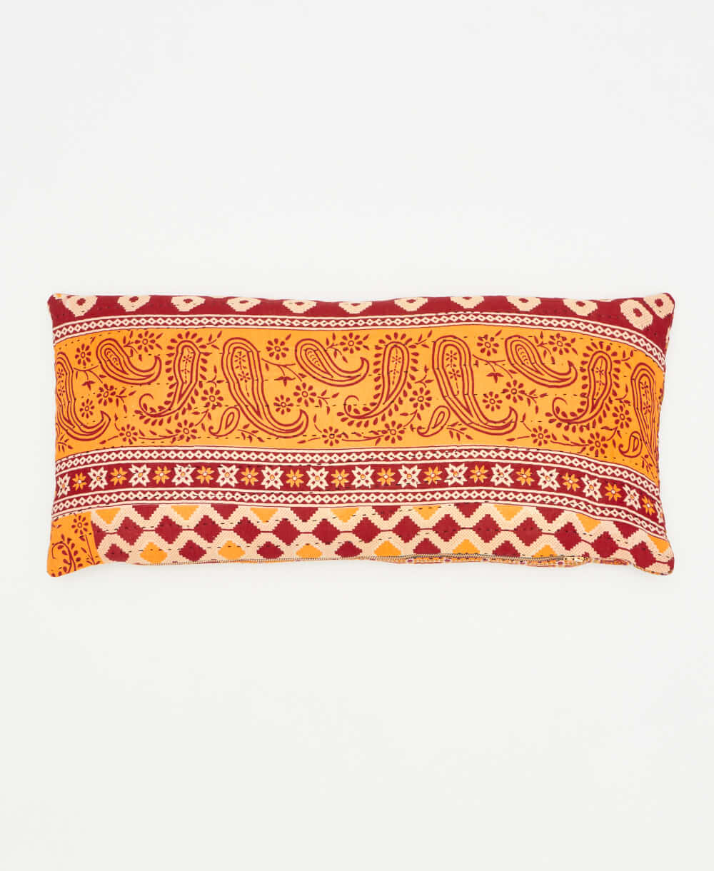 lumbar pillow featuring a red and yellow paisley print handmade by women 