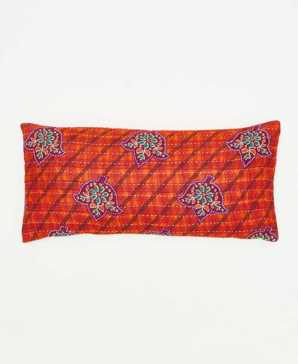 tangerine orange lumbar pillow featuring a purple floral print 