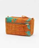 cosmetic travel bag in an orange & teal flower print with black hand-stitched kantha embroidery