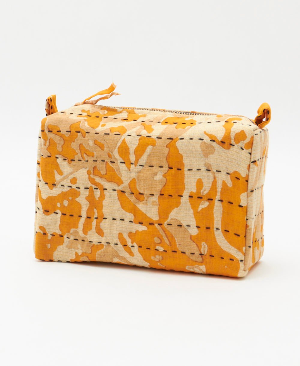 cosmetic travel bag in orange and ivory abstract print with black hand-embroidered stitching