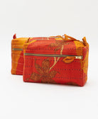 small makeup bag in dark orange and bold yelloe abstract print with hand-stitched embroidery