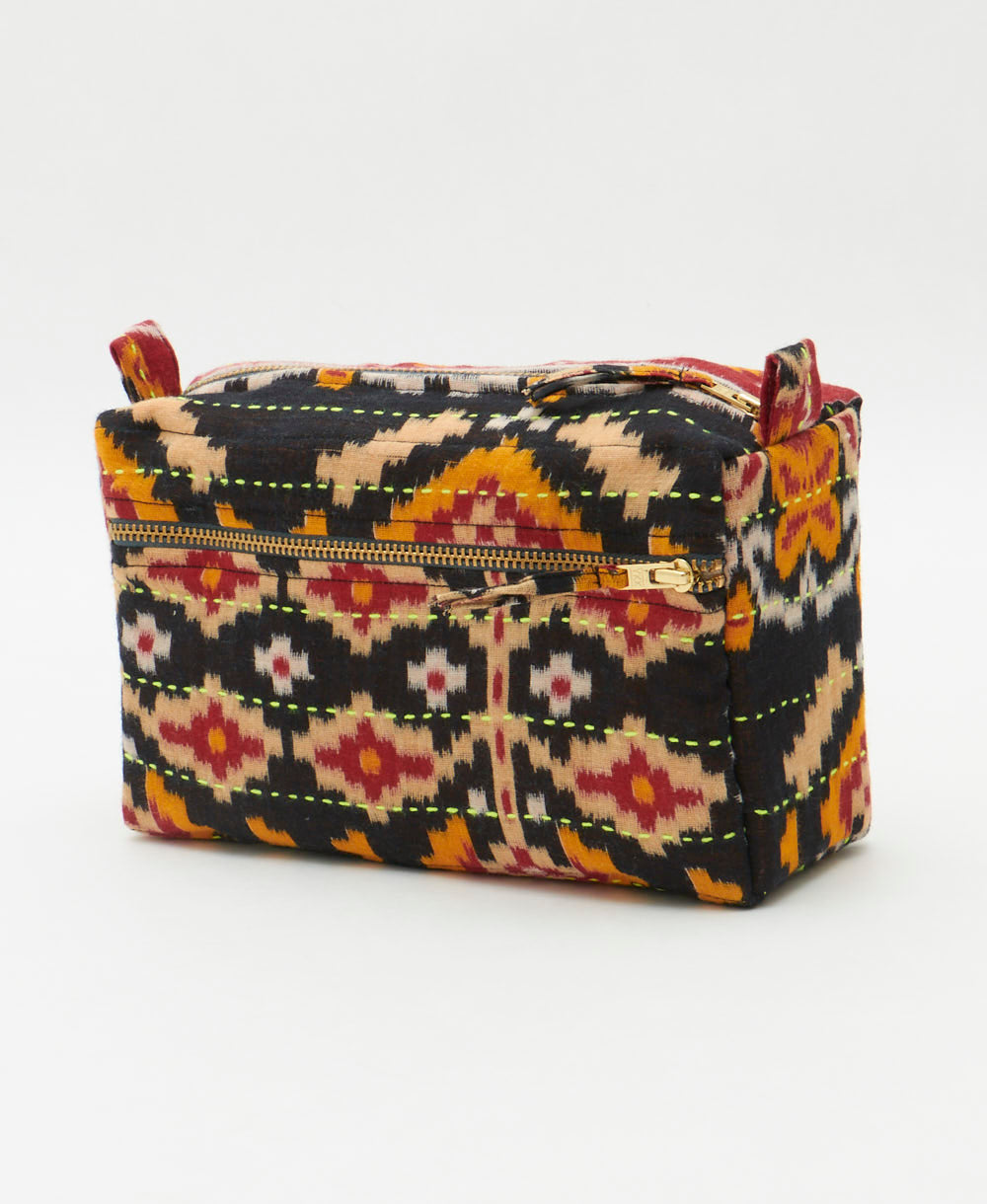 black medium toiletry bag in a tan, orange and red geometric southwestern print handmade from vintage saris