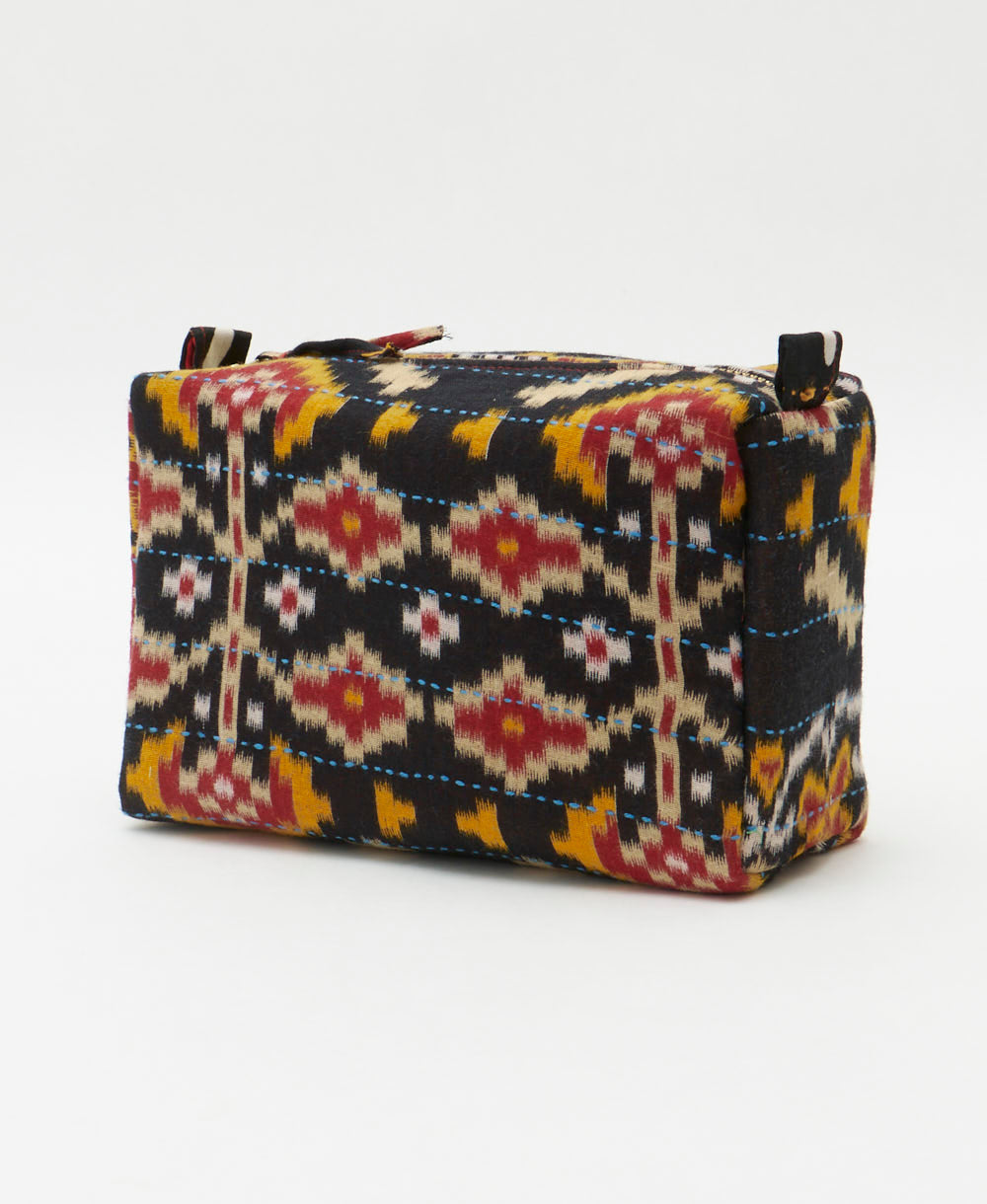 cosmetic travel bag in a black geometric southwestern pring with light blue embroidery