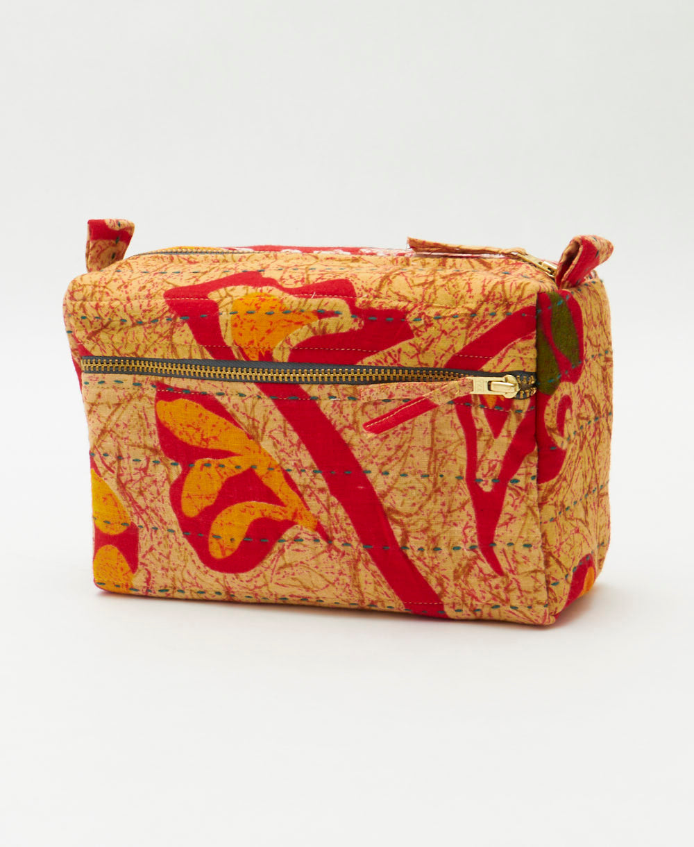 tan medium toiletry bag in red and orange abstract print with dark green embroidery