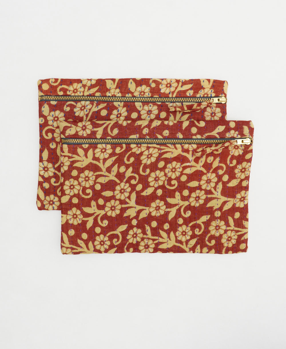 hand-embroidered small pouches with different colored thread in a red and tan daisy print