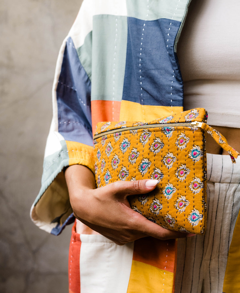 Woman holding vintage kantha pouch clutch getting ready for
a night out