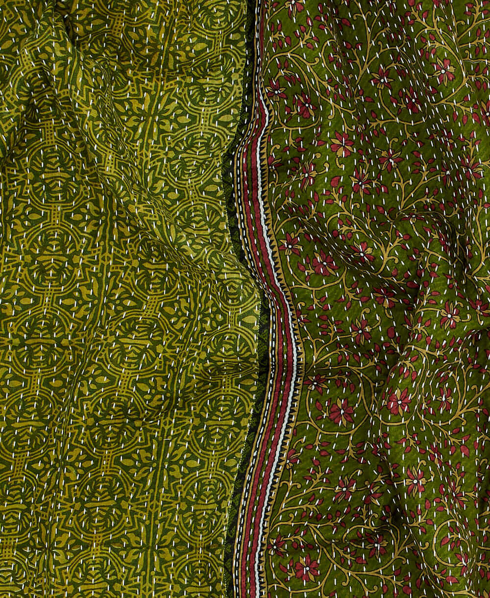 magenta and forest green kantha quilt throw with a tag featuring the hand-stitched signature of the maker