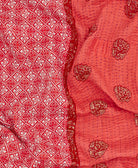 Coral kantha quilt throw with a tag featuring the hand-stitched signature of the maker