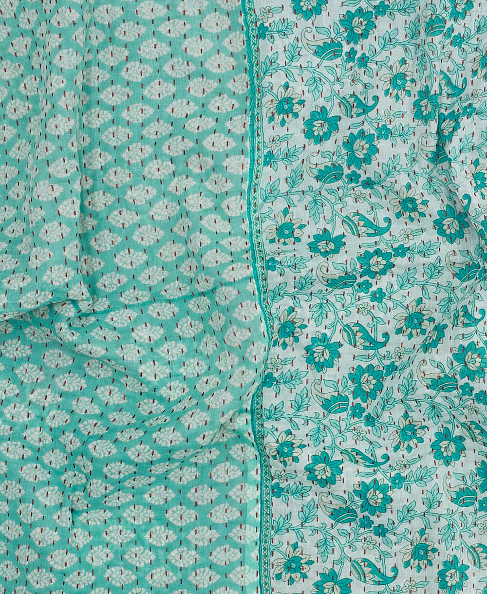 Blue floral paisley kantha quilt throw with a tag featuring the hand-stitched signature of the maker