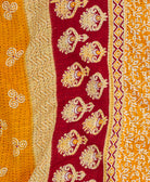 orange kantha quilt throw with a tag featuring the hand-stitched signature of the maker