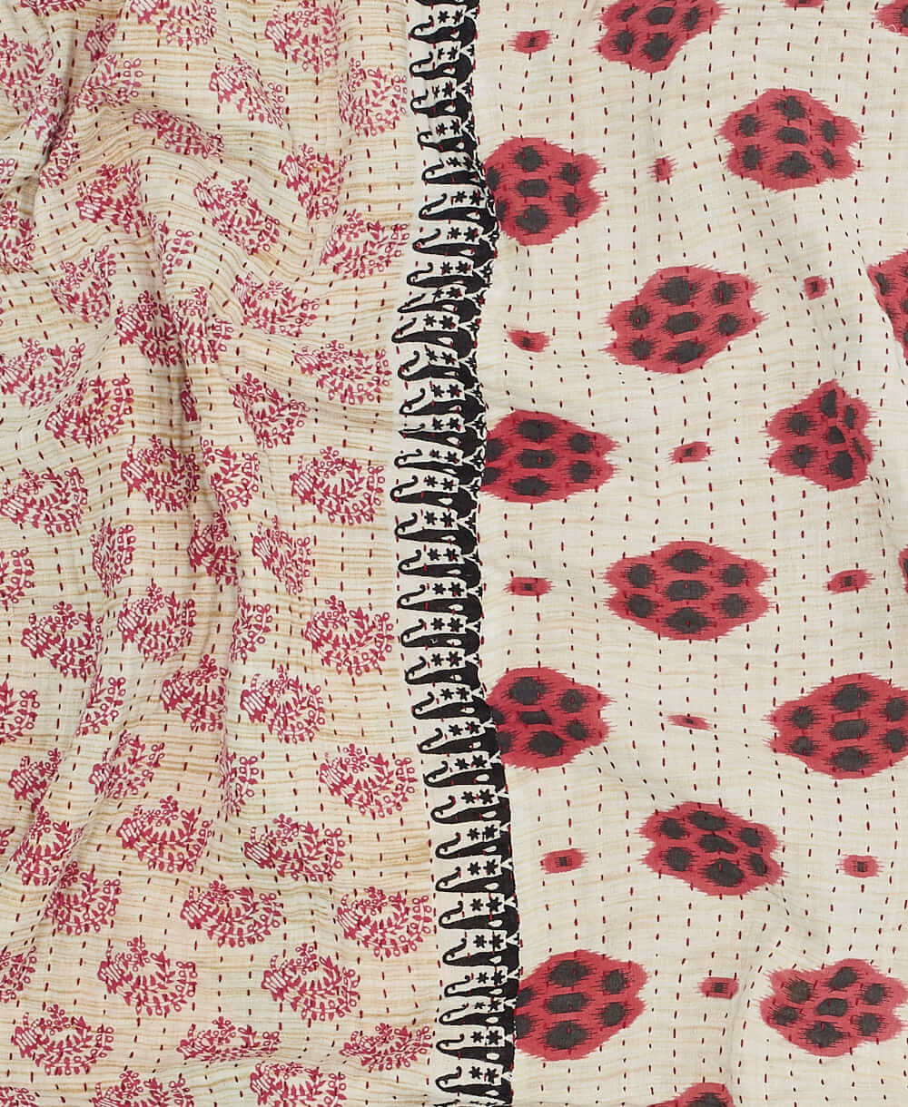 red kantha quilt throw with a tag featuring the hand-stitched signature of the maker