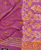 Purple kantha quilt throw with a tag featuring the hand-stitched signature of the maker