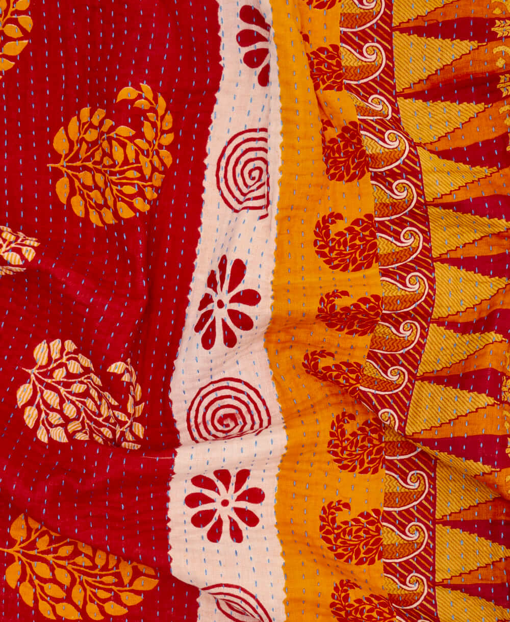 mustard yellow paisley kantha quilt throw with a tag featuring the hand-stitched signature of the maker