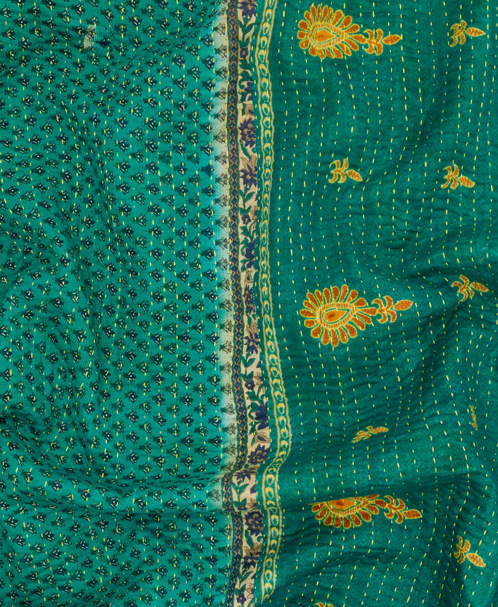  teal and yellow stamp paisley  kantha quilt throw with a tag featuring the hand-stitched signature of the maker