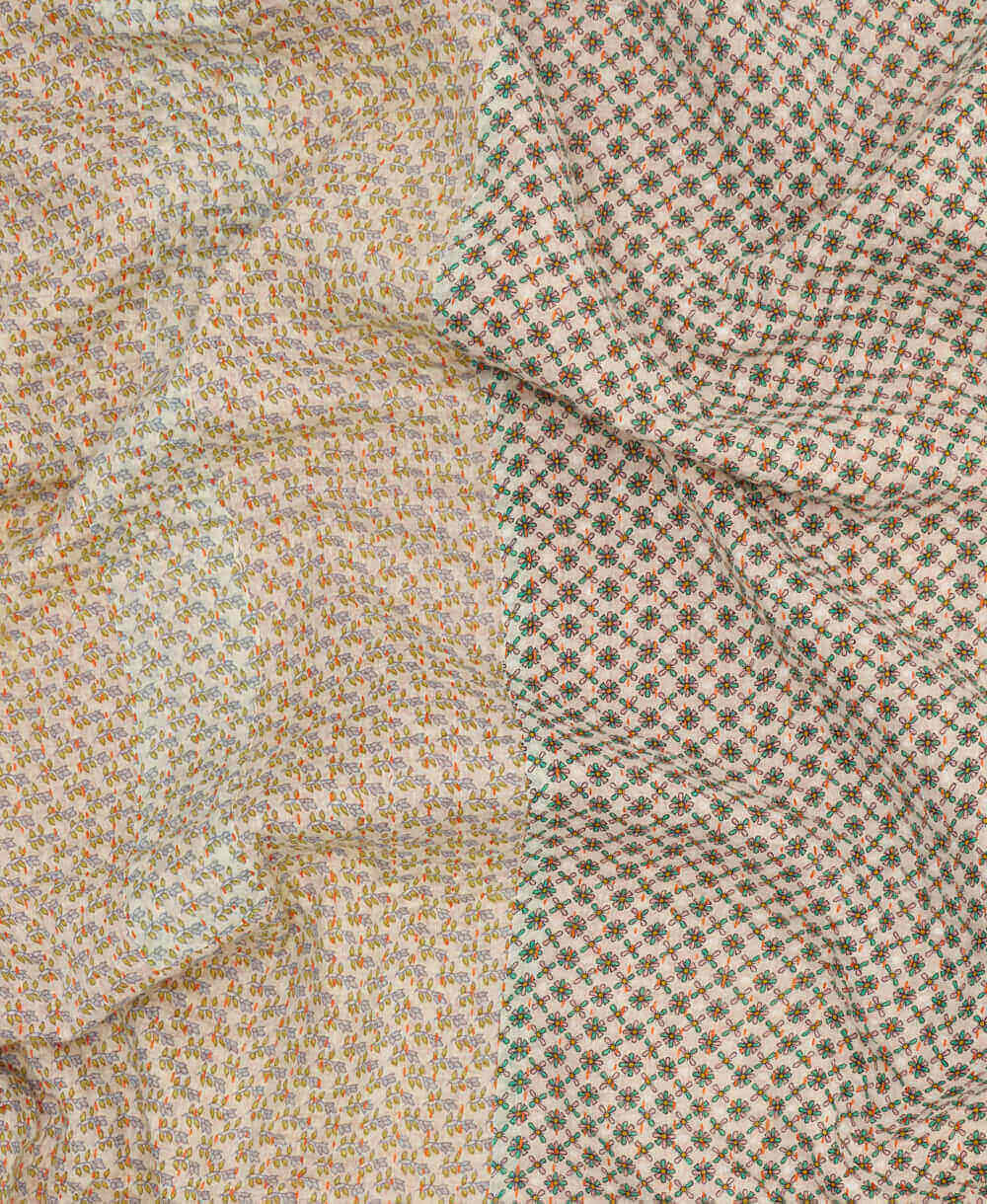  khaki floral kantha quilt throw with a tag featuring the hand-stitched signature of the maker