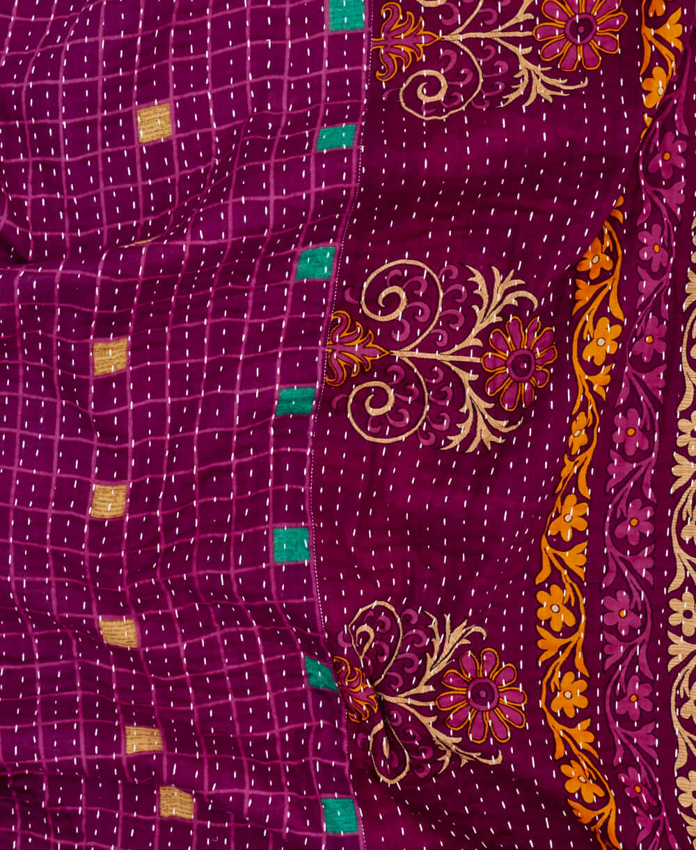 bright purple geometric kantha quilt throw with a tag featuring the hand-stitched signature of the maker