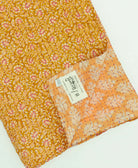  sunshine yellow & pastel orange kantha quilt throw with a tag featuring the hand-stitched signature of the maker